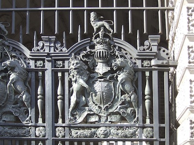 The Lion and the Unicorn are astride the shield, there is a hat on the sheild and upon it sit another lion, that is quite small and is also wearing a hat
